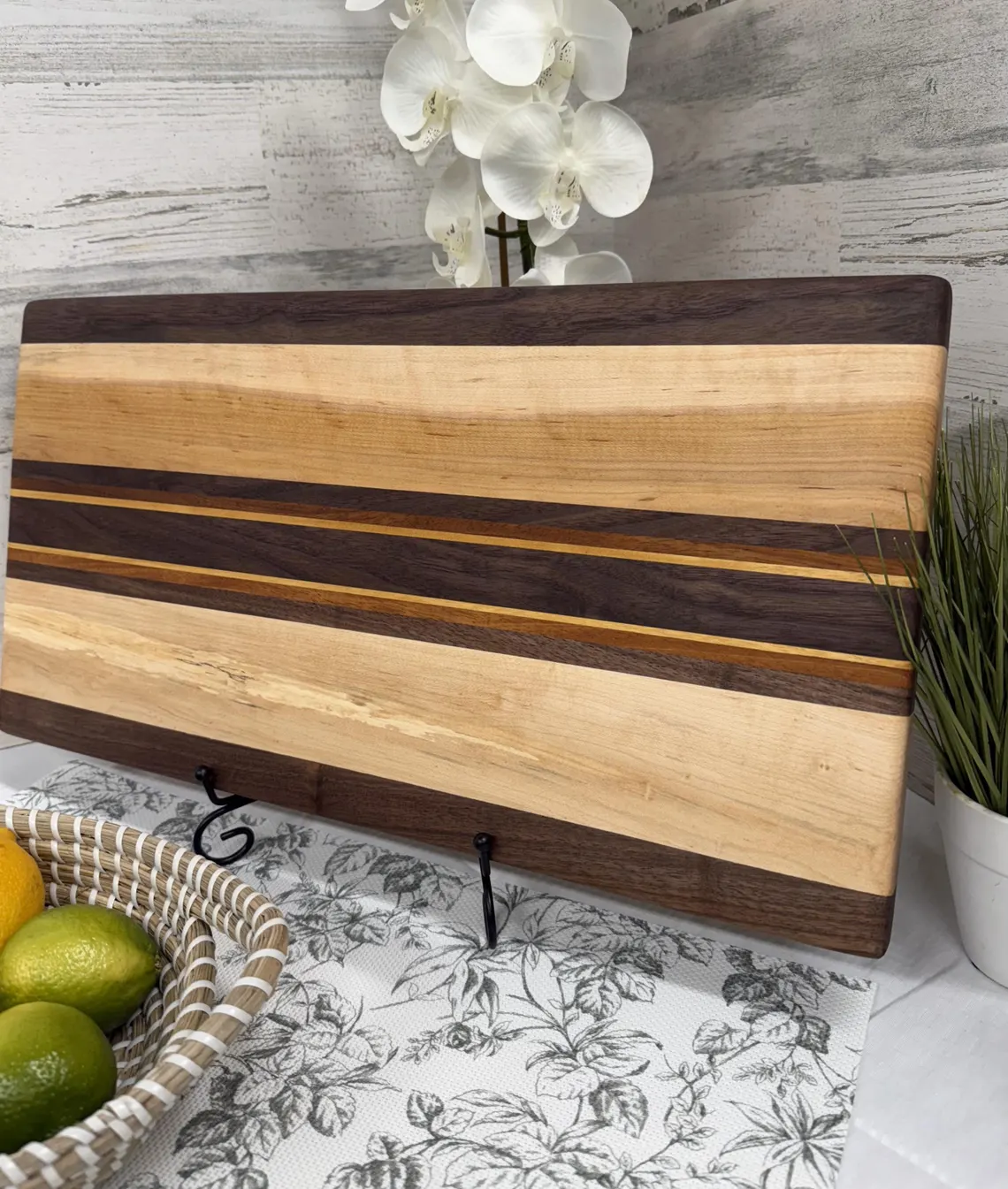 Layered black walnut and maple cutting board with contrasting wood accent stripes