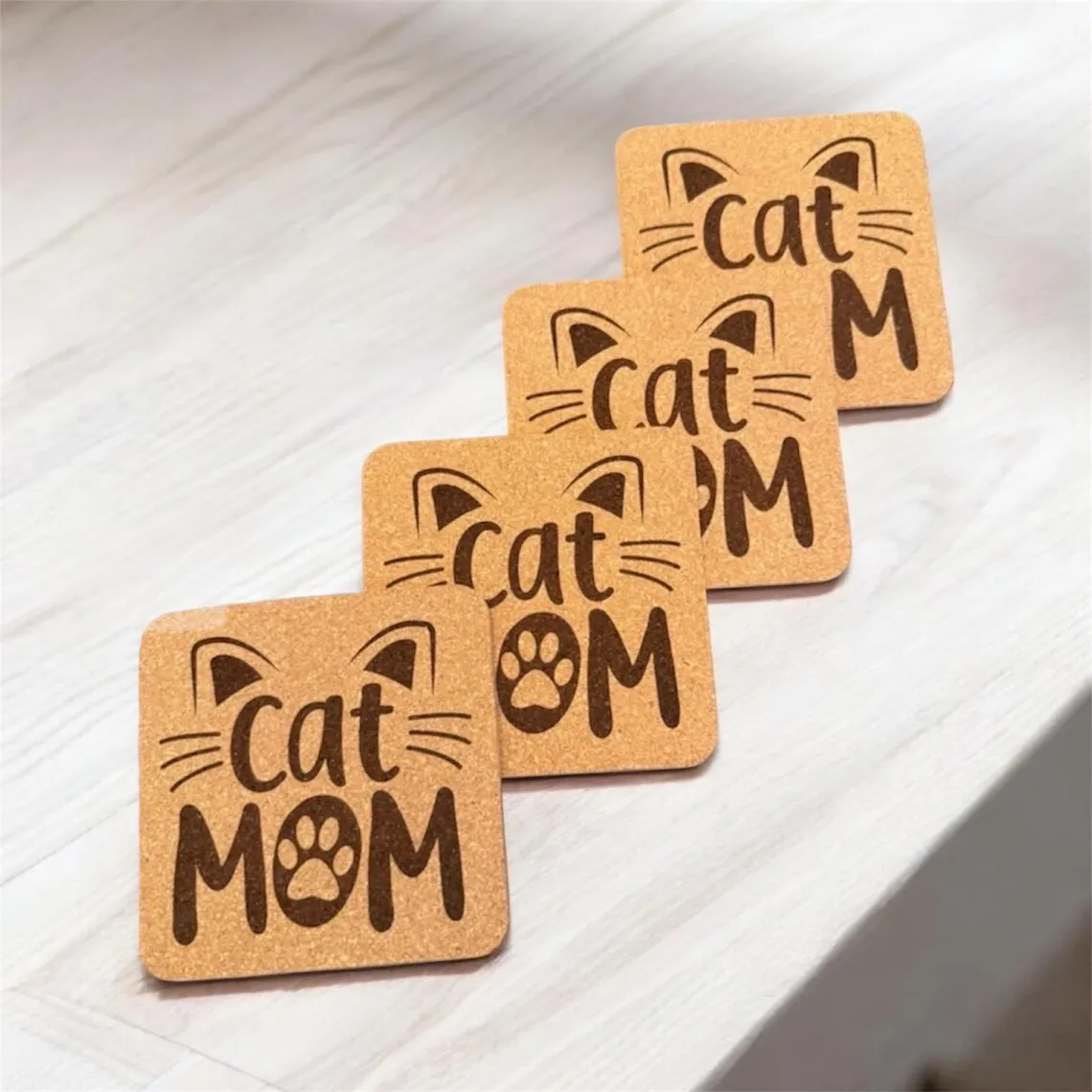 Square cork coasters laser engraved with a cat face and 'Cat Mom' lettering