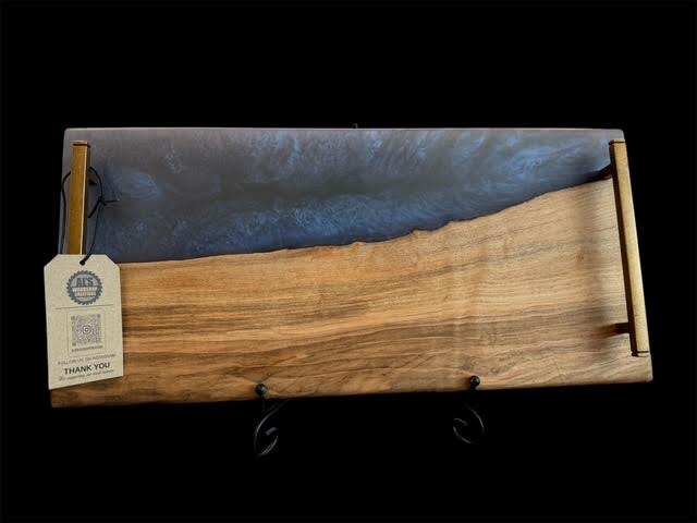 Live-edge wood serving board with blue epoxy resin river